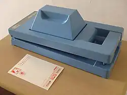 Boîtier fermé avec carte postale devant.