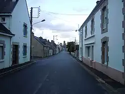 Photographie en couleurs d'une rue bordée de maisons.