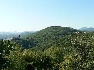 Puy de la Bannière vu depuis Beauvaleix (hameau de la commune d'Enval). Sur un des contreforts du puy, à gauche : le château de Tournoël. En arrière-plan à droite : le puy de Dôme.