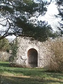 Vue du pignon d'une chapelle percé d'une porte romane.