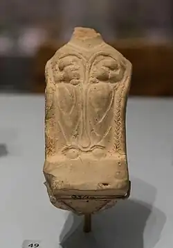 Statue de femme sans tête, assise tenant deux enfants contre sa poitrine