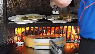 Préparation de raclette au feu de bois.