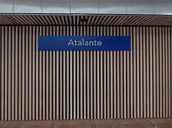 Le nom des stations est inscrit en blanc sur des panneaux à fond bleu.