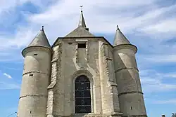 Le chevet en pierre calcaire date du XVIe&nbsp;siècle. Il est flanqué de deux tours percées de meurtrières.