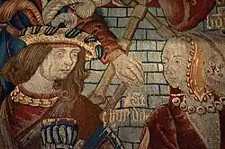 Motif coloré de tapisserie représentant deux visages se faisant face.