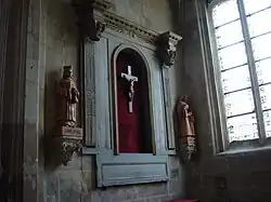 Retable classique d'une des chapelles latérales (en provenance de l'église Sainte-Cécile). Le retable est incomplet, par l'absence des colonnes ; les chapiteaux des colonnes qui subsistent sont d'ordre corinthien. Le retable possède une niche, avec une croix dans son centre.