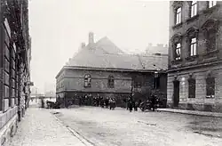 Photographie en noir et blanc d'une rue avec plusieurs personnes à l'arrière-plan