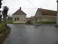 Meule de moulin érigée en monument à un carrefour.