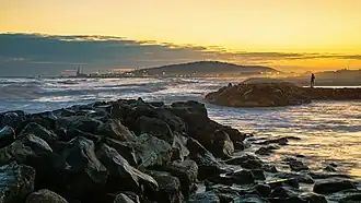 Coucher de Soleil sur la plage de Frontignan en regardant vers Sète. Le mont Saint-Clair se détache dans la langue de nuages.  Février 2023.