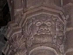 Chapiteau à tête grimaçante