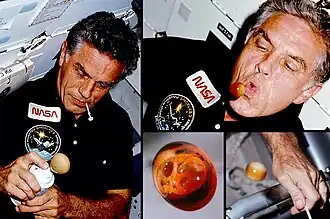 Karl Henize, spécialiste de la mission STS-51F, crée des boules de Pepsi mousseuses et pétillantes lors de l'évaluation du distributeur de boissons gazeuses