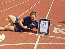 Stephen Wildish et son certificat du Guinness World Records pour son record du monde au 100 mètres en sac (26,22&nbsp;s en 2017),.