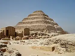 Ruines du complexe funéraire du roi Djéser à Saqqarah, dominées par sa pyramide à degrés, XXVIIe&nbsp;siècle.