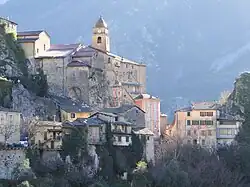L'entrée nord du village avec le chevet de l'église Saint-Sauveur et la chapelle des Pénitents rouges.