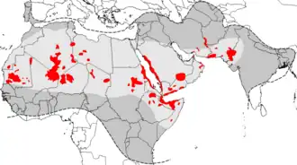 Aires de répartition du criquet pèlerin. En rouge, les zones principales de pullulation pouvant être à l'origine d’une invasion (outbreak areas en anglais) ; en gris clair, les zones de rémission (aire normale d'habitat du criquet pèlerin en phase solitaire ; les zones en gris clair et &nbsp;gris foncé représentent ensemble l'aire d'invasion (aire totale pouvant être envahie par les essaims en cas d'invasion généralisée).