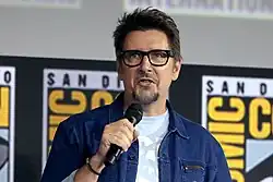 Homme en veste bleue tenant un microphone