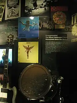 Photographie d'une vitrine dans un musée exposant des photos et des pochettes d'albums