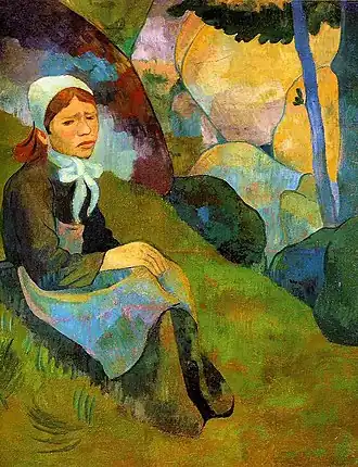 Tableau représentant une jeune fille en tenue bretonne, seule, assise dans l'herbe. Elle est assise devant des rochers ou des arbres aux couleurs vives, jaunes ou avec des reflets bleus.