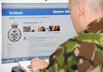 Un militaire accède à la page Facebook des Forces armées britanniques à l'aide d'un ordinateur de bureau.