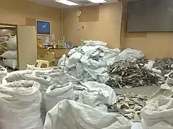 De grands sacs entassés débordant d'ailerons secs.