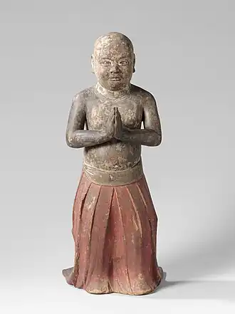 Shōtoku enfant, debout, les mains jointes en signe d'adoration. Il porte une robe rouge plissée, entre 1200 et 1350, bois sculpté peint, 74,5&nbsp;×&nbsp;32&nbsp;×&nbsp;40&nbsp;cm, Rijksmuseum Amsterdam, Pays-Bas.