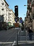 Image représentant un feu tricolore de tramway avec la barre horizontale marquant l’arrêt, le SAC avec losange orange indiquant la prise en charge de la priorité et le point d’exclamation bleu indiquant le passage à la barre verticale allumés, ainsi que la vitesse limitée à 30&nbsp;km/h à la station Palais des expositions.
