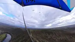 Des parepentistes et deltistes en vol au dessus du site du décollage de Douelle