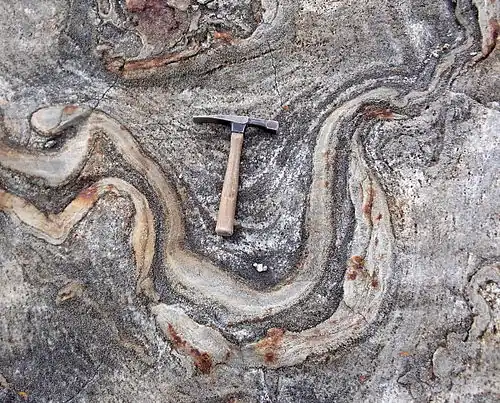 Un marteau de géologue donnant la dimension d'un pli dans la roche.