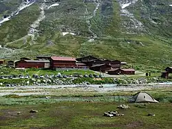 Ensemble de bâtiments rouges et parking au fond d'une vallée.
