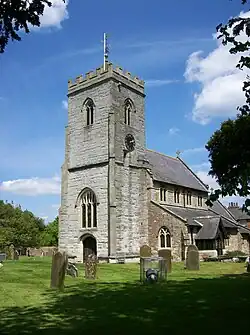 Photo d'un bâtiment en pierre grise avec une grande tour carrée crénelée