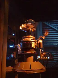 Robot gris et bleu devant un écran.