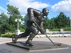 Photographie en couleur d'une statue en plein air représentant Maurice Richard en train de patiner sur la glace