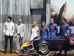 Photo d'officiels de Red Bull Racing et d'une monoplace bleue, célébrant un partenariat avec un film