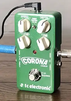 Photo d'une pédale d'effet rectangulaire verte, Corona Chorus, avec quatre potentiomètres blancs (Speed, Depth, FX Level, Tone), deux entrées et deux sorties jack et une prise d'alimentation