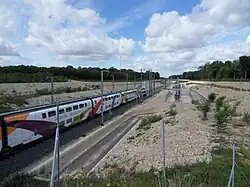 Le train d'essai recouvert de son pelliculage spécial, constitué d'une rame TGV DASYE composée de 8 voitures encadrées par 2 motrices au cours d'une marche d’essai sur voie 1 dans le sens Villers-les-Pots — Mulhouse à proximité de la section de séparation 1,5&nbsp;kV/25&nbsp;kV de Villers-les-Pots.
