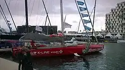 Vu de trois quarts arrière, voilier rouge amarré au ponton.