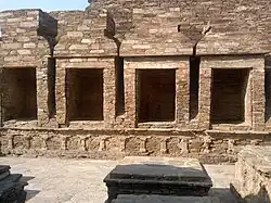 Cour des stupas votifs : chapelles en maçonnerie diaprée, toit à double dôme construit en encorbellement, décor de pilastres. IVe&nbsp;siècle