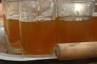 Plusieurs verres pleins de thés sur un plateau argenté.