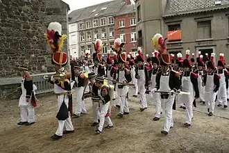 Sapeurs qui passent devant l'église lors de la marche Saint-Roch.