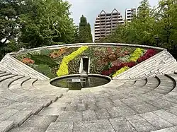 Photo couleur d'un mémorial fleuri dans un parc.