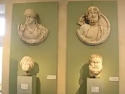 Deux boucliers exposés avec des têtes sculptées.