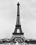Tour Eiffel en acier construite pour l'Exposition universelle de Paris de 1889 célébrant le centenaire de la Révolution française. Architecture affirmée par des arcs rajoutés à sa base.