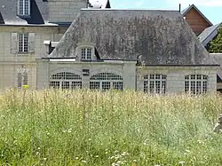 Photographie d'un bâtiment dont les arcades sont garnies de grands baies vitrées.