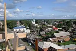 Vue d'une zone de Ienisseïsk avec des bâtiments en bois et l'église du monastère de la Transfiguration du Sauveur.