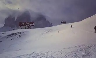 Tre Cime dans les nuages en hiver ; au premier plan, le refuge A. Locatelli.