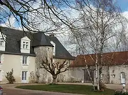 Photographie en couleurs d'un bâtiment dont une façade porte une tourelle hexagonale.