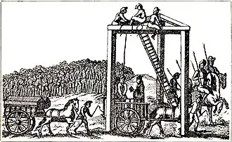Une illustration monochrome d'une structure à trois pieds avec des poutres pour relier chaque pied au sommet (formant un triangle équilatéral sur son côté). Plusieurs hommes sont assis en haut de la structure, près d'une échelle, à environ 600 mètres de haut. Une corde relie le sommet de la structure au cou d'un homme, debout sur une charrue. Un autre homme lit un livre, tourné vers lui. Des chevaux tirent une autre charrue, sur laquelle on peut voir deux cercueils. Une grande foule est réunie au loin, regardant la scène.