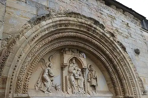 Vue latérale du portail (tympan et ornementations) de l’ancienne prieurale