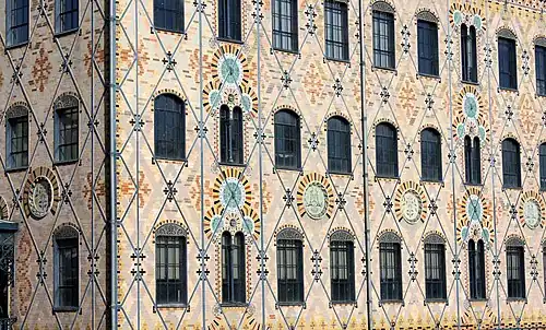 Détail de la façade, montrant l'armature métallique exposée et les briques polychromes