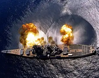 Le cuirassé américain USS Iowa tirant une bordée de ses 3 pièces triples de 406 mm.